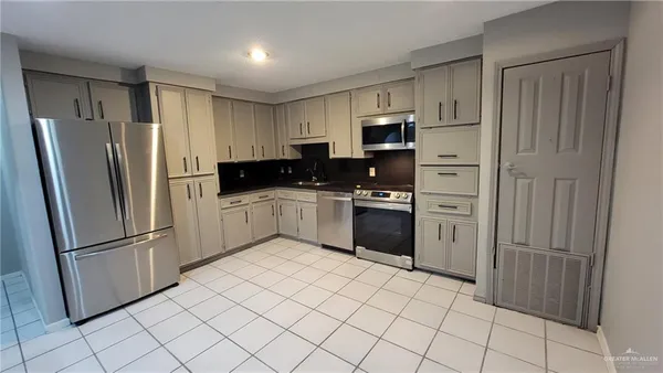 a kitchen with stainless steel appliances a refrigerator sink and microwave