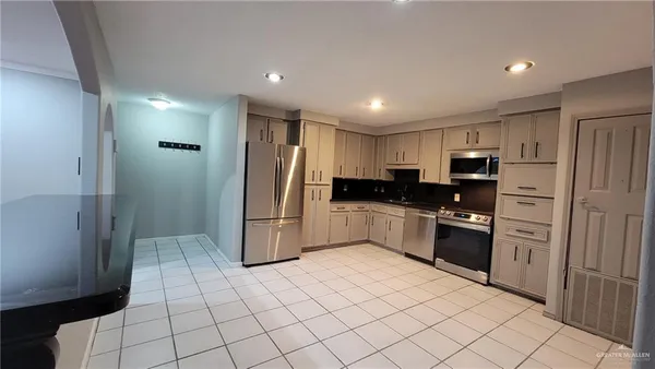 a kitchen with stainless steel appliances granite countertop a refrigerator and a sink