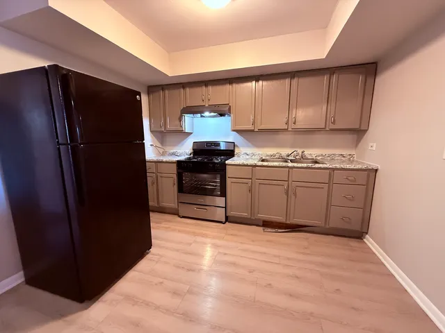a kitchen with stainless steel appliances granite countertop a refrigerator and a sink