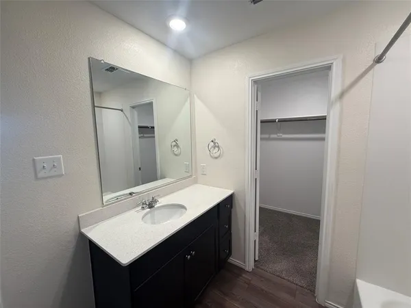 a bathroom with a sink vanity and mirror