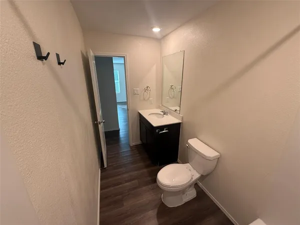 a bathroom with a sink a toilet a mirror and vanity