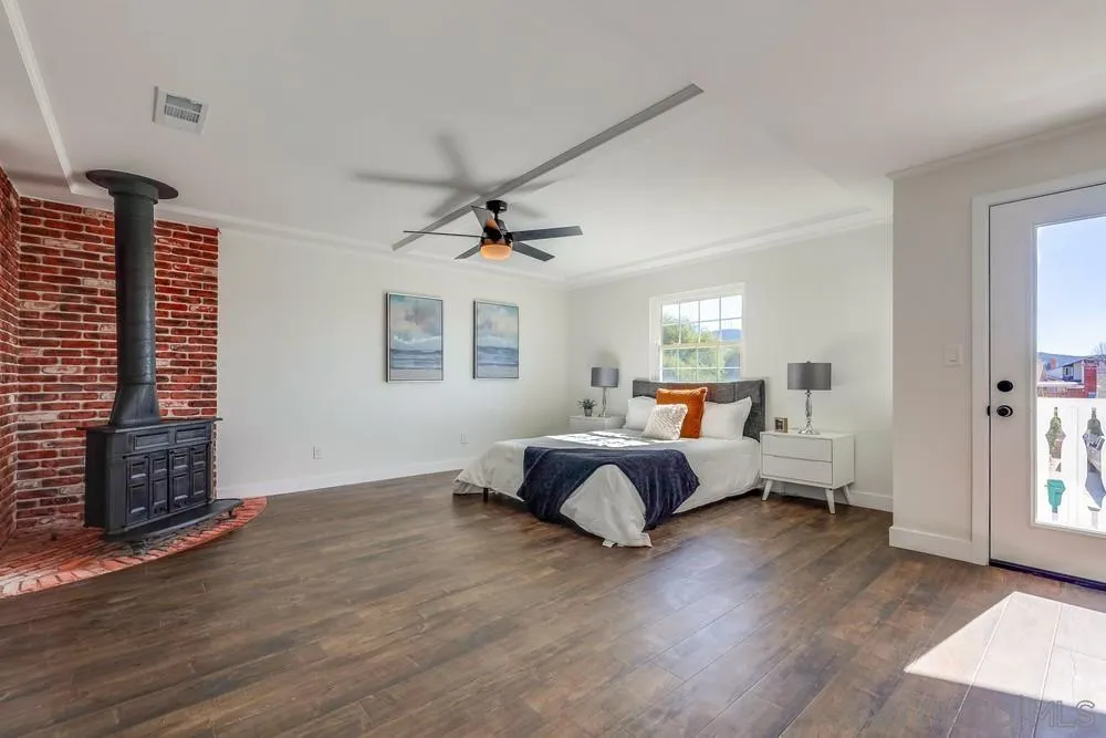 8779 Cordial Road El Cajon, CA 92021 - Photo 16 of 39 a spacious bedroom with a bed and wooden floor