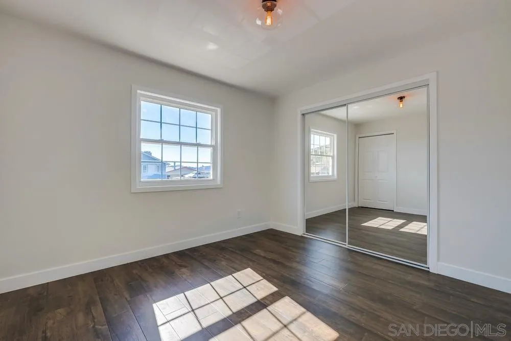 8779 Cordial Road El Cajon, CA 92021 - Photo 21 of 39 an empty room with wooden floor and windows