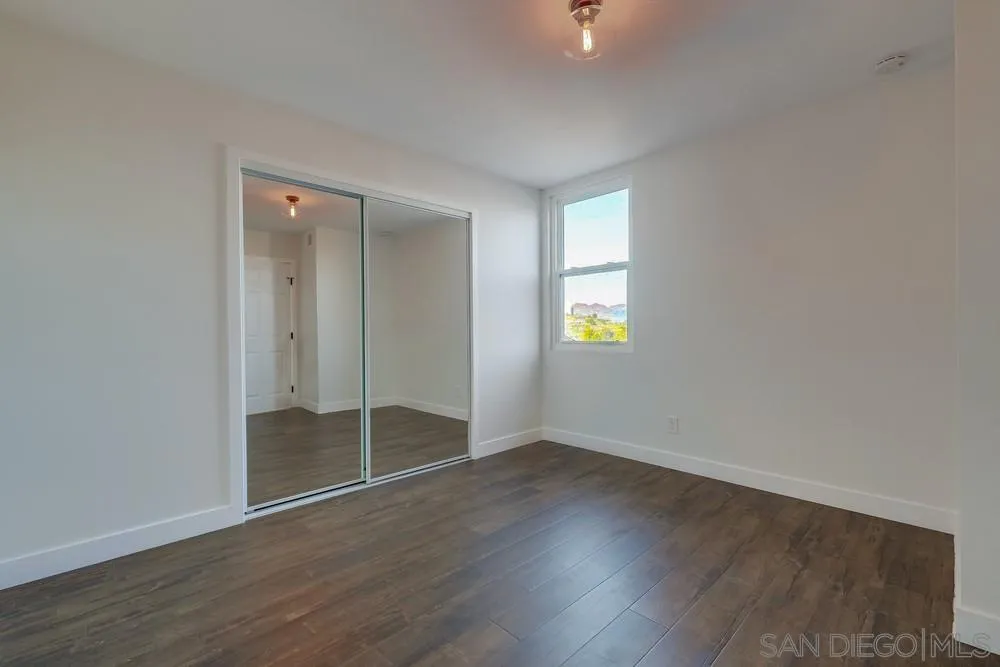8779 Cordial Road El Cajon, CA 92021 - Photo 22 of 39 an empty room with wooden floor and windows