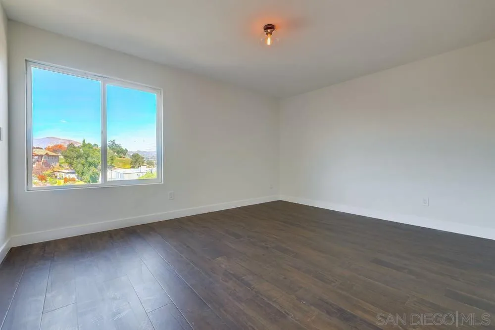 8779 Cordial Road El Cajon, CA 92021 - Photo 23 of 39 a view of an empty room with wooden floor and a window