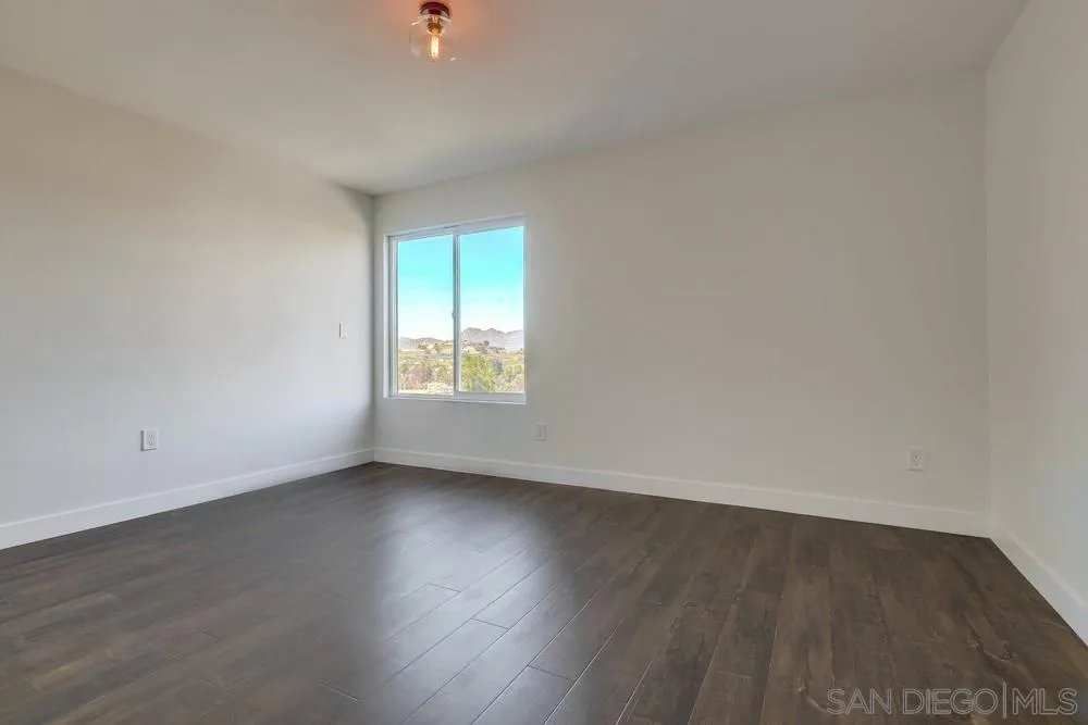 8779 Cordial Road El Cajon, CA 92021 - Photo 24 of 39 an empty room with wooden floor and windows