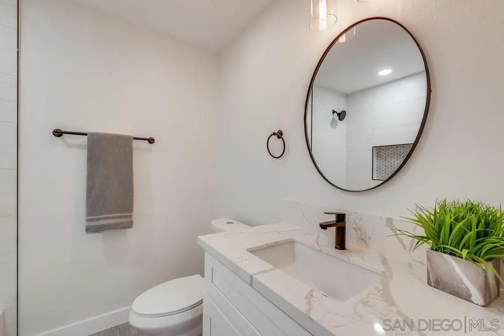 8779 Cordial Road El Cajon, CA 92021 - Photo 25 of 39 a bathroom with a sink a toilet and a mirror