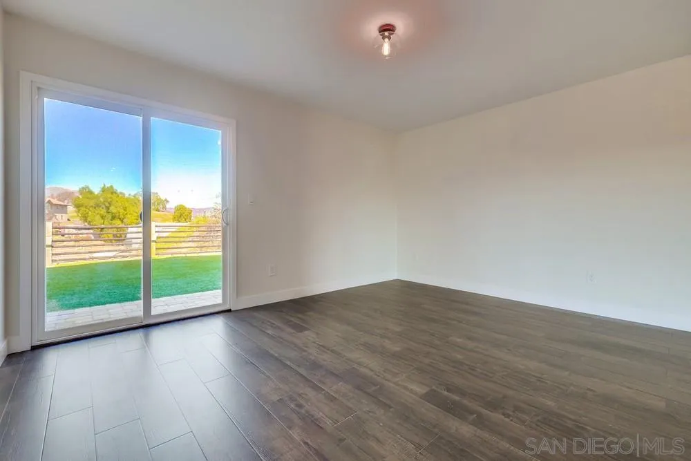 8779 Cordial Road El Cajon, CA 92021 - Photo 27 of 39 a view of an empty room with wooden floor and a window