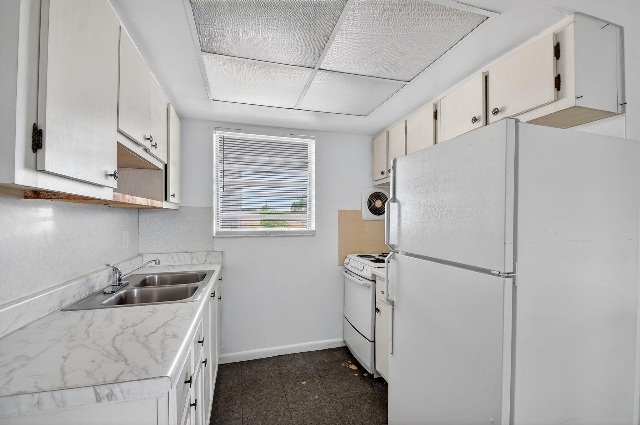 1406 Barton Road, Unit 15 Lake Worth Beach, FL 33460 - Photo 12 of 19 a kitchen with cabinets stainless steel appliances and a window
