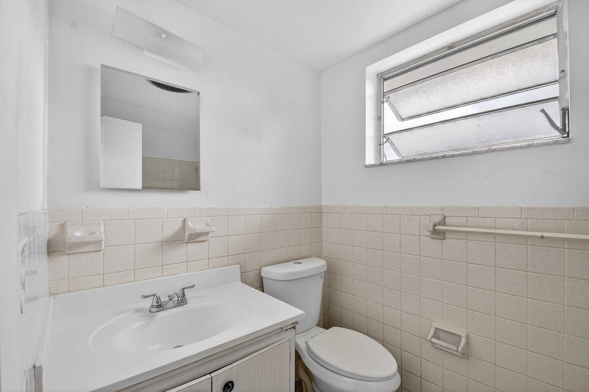 1406 Barton Road, Unit 15 Lake Worth Beach, FL 33460 - Photo 17 of 19 a bathroom with a sink mirror and toilet