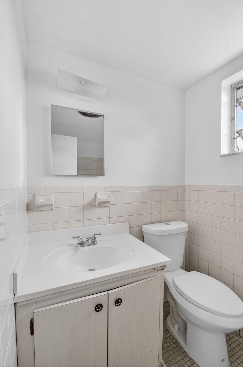 1406 Barton Road, Unit 15 Lake Worth Beach, FL 33460 - Photo 19 of 19 a bathroom with a toilet sink and mirror