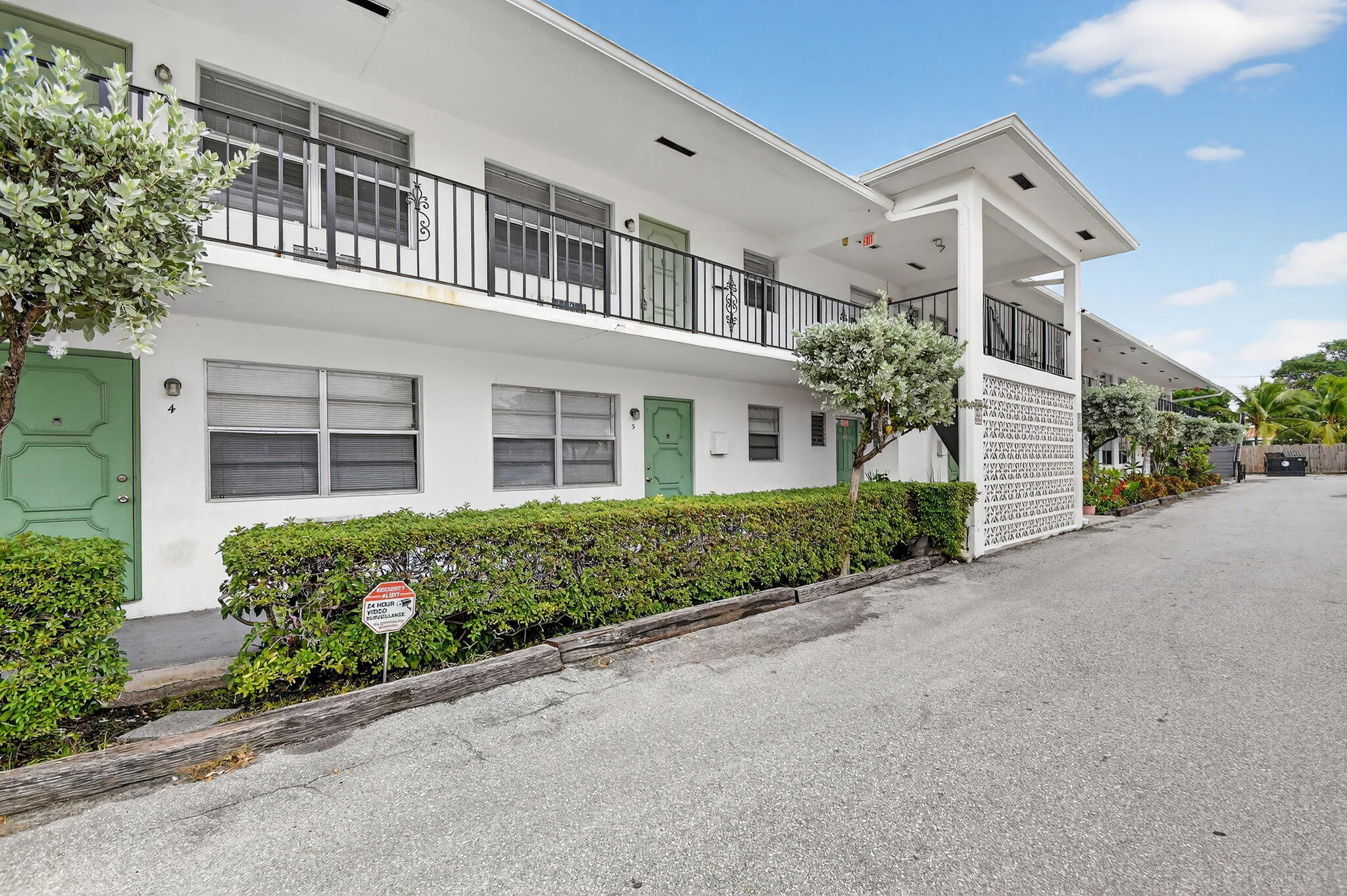 1406 Barton Road, Unit 15 Lake Worth Beach, FL 33460 - Photo 2 of 19 front view of a house with a garden