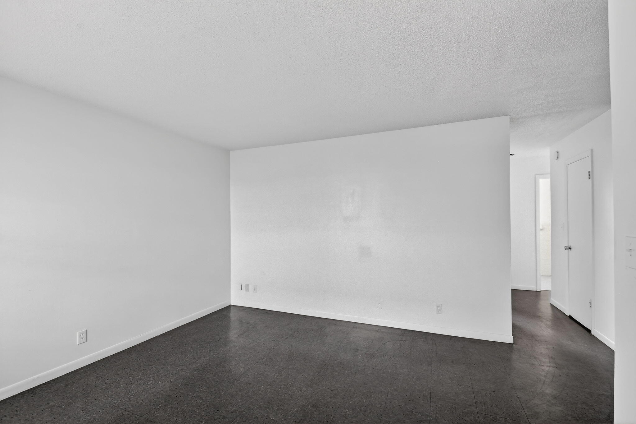 1406 Barton Road, Unit 15 Lake Worth Beach, FL 33460 - Photo 5 of 19 an empty room with wooden floor and windows