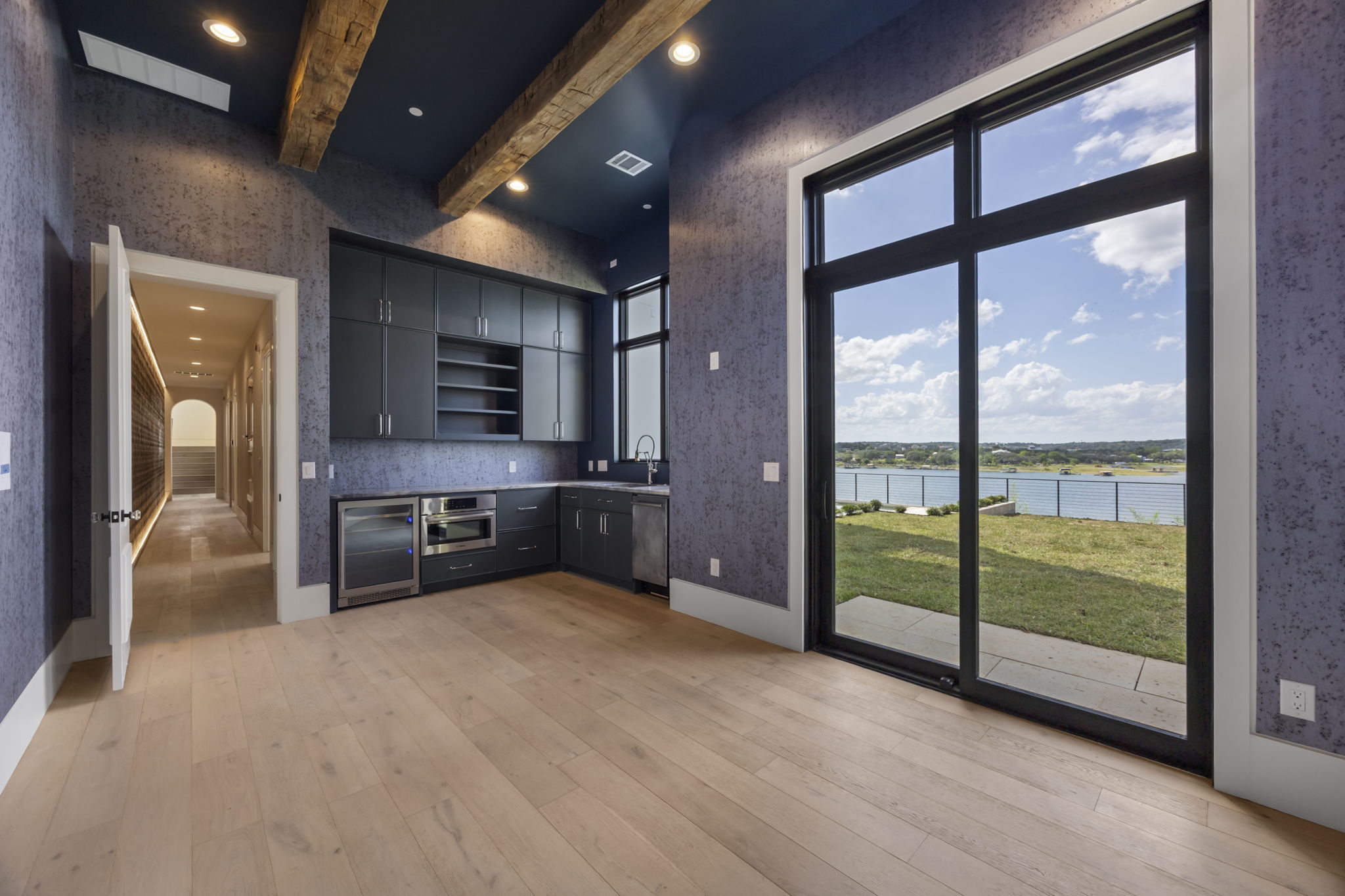 1496 Buffalo Gap Road Lakeway, TX 78734 - Photo 30 of 37 A wet bar with natural wood floors and beamed ceilings offers captivating waterfront views.