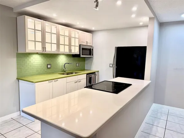 a kitchen with stainless steel appliances a microwave a sink and white cabinets