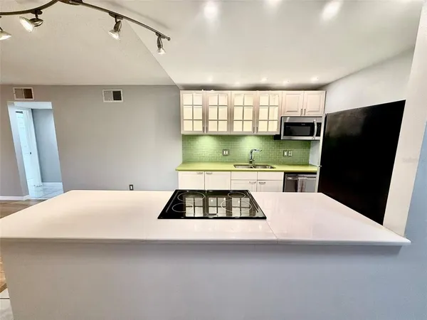 a kitchen with a refrigerator a stove a microwave and cabinets