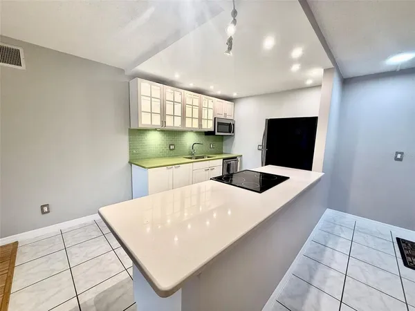 a kitchen with stainless steel appliances kitchen island a white stove top oven and cabinets
