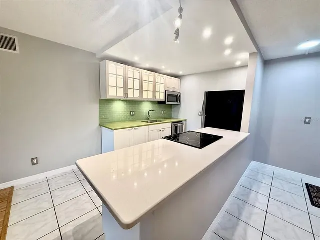 a kitchen with stainless steel appliances kitchen island a white stove top oven and cabinets