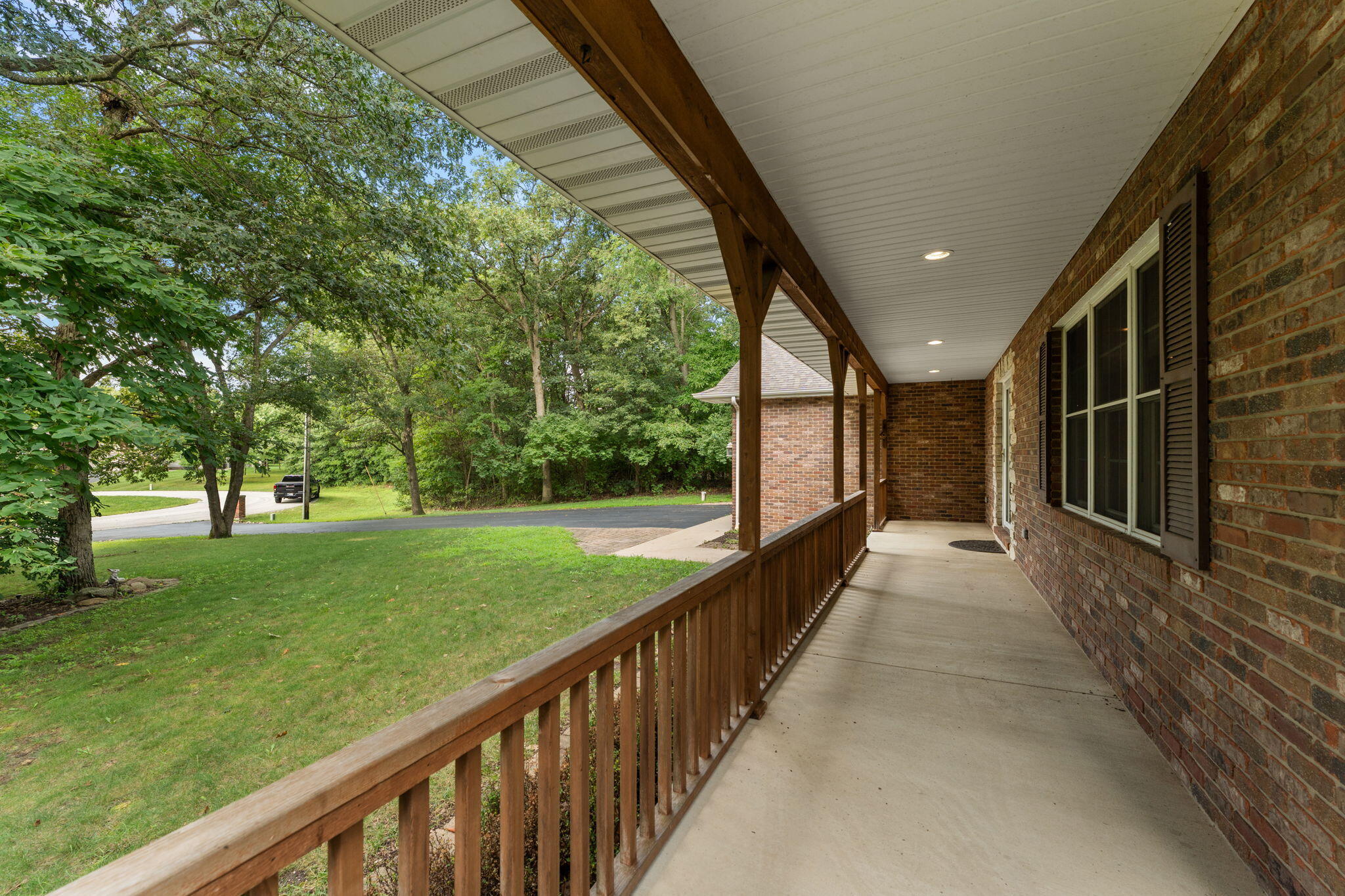 5338 East Lawler Court, Unit 67 Demotte, IN 46310 - Photo 34 of 49 a view of a porch with a big yard and large trees