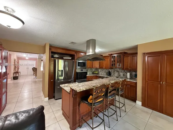 a kitchen with a table chairs refrigerator and cabinets