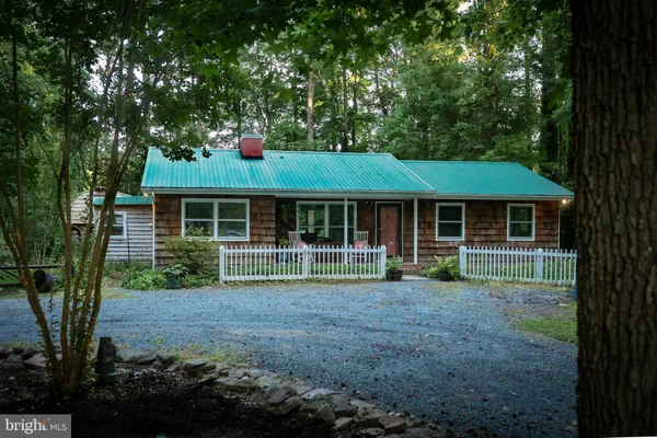 a front view of a house with a yard and green space