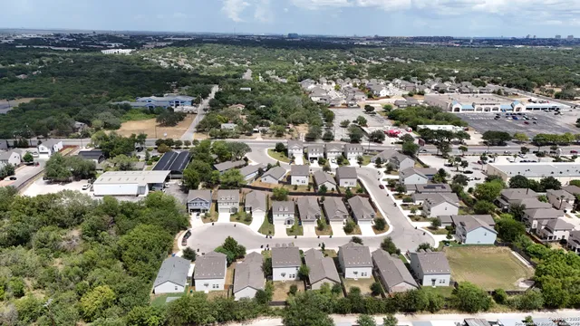 an aerial view of residential building with parking and trees