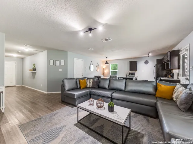 a living room with furniture and wooden floor