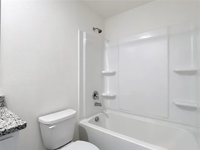 a white toilet sitting next to a bath tub
