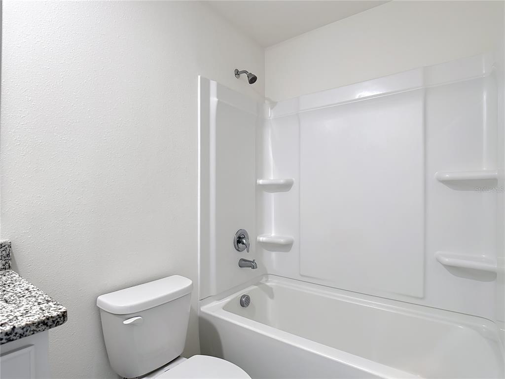 6632 Druid Way St. Cloud, FL 34773 - Photo 14 of 38 a white toilet sitting next to a bath tub