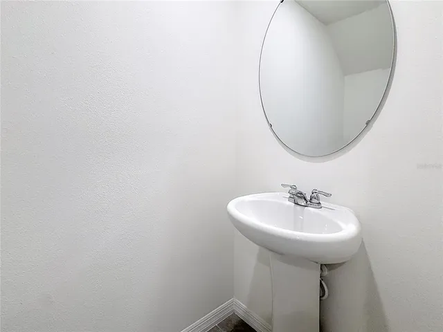 a bathroom with a sink a mirror and a gate