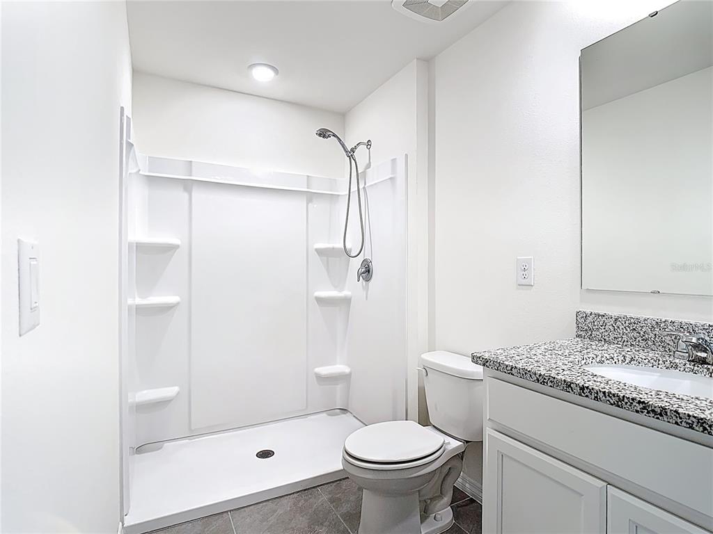 6632 Druid Way St. Cloud, FL 34773 - Photo 24 of 38 a bathroom with a granite countertop sink a toilet and shower