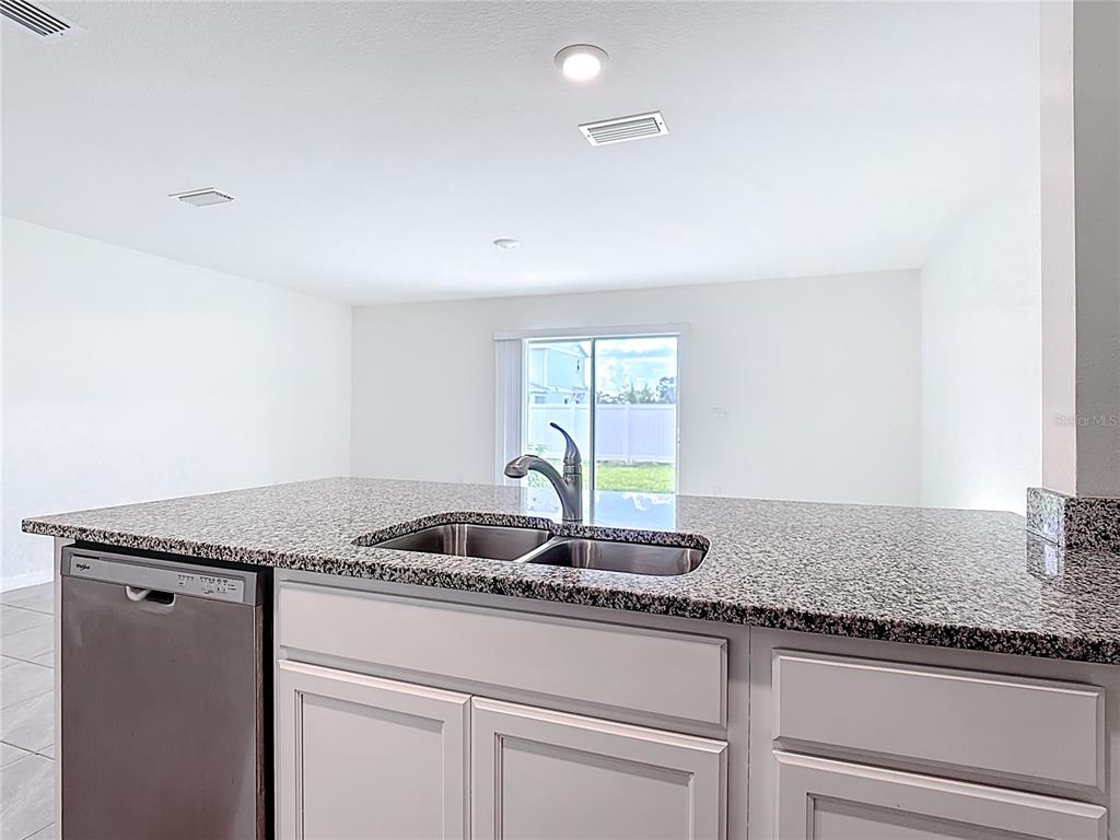 6632 Druid Way St. Cloud, FL 34773 - Photo 25 of 38 a kitchen with granite countertop a sink and a window