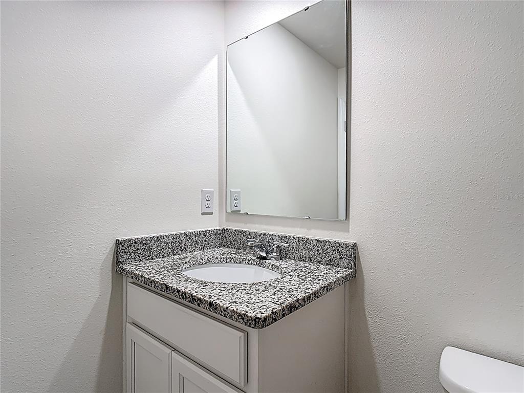 6632 Druid Way St. Cloud, FL 34773 - Photo 27 of 38 a bathroom with a granite countertop sink and a mirror