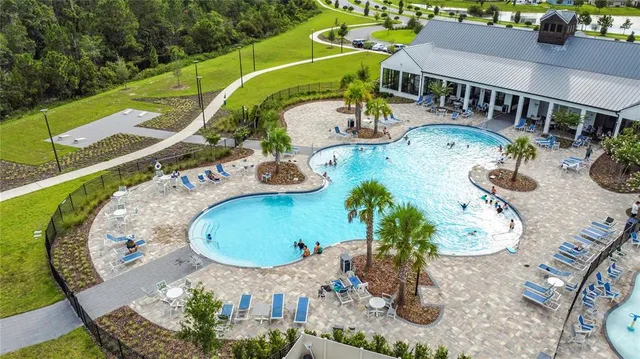 an aerial view of a house with swimming pool patio and outdoor seating