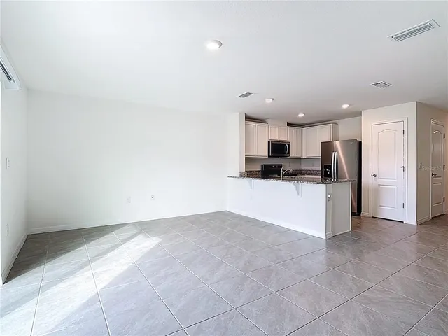 a view of kitchen with stainless steel appliances kitchen island granite countertop a refrigerator oven a sink and dishwasher