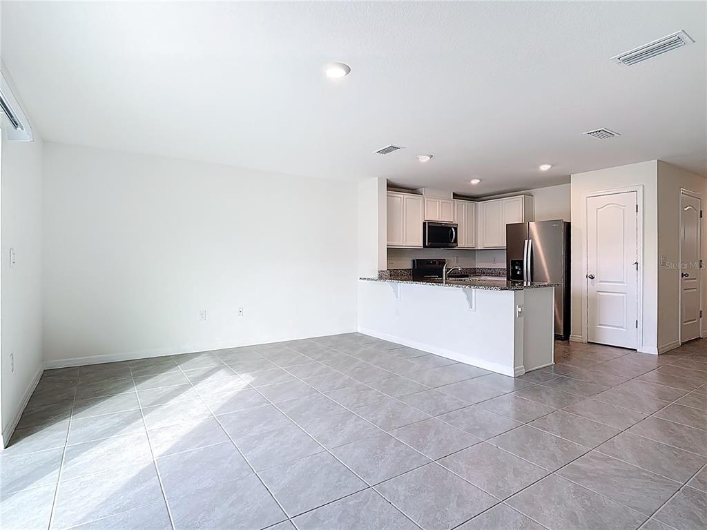 6632 Druid Way St. Cloud, FL 34773 - Photo 6 of 38 a view of kitchen with stainless steel appliances kitchen island granite countertop a refrigerator oven a sink and dishwasher
