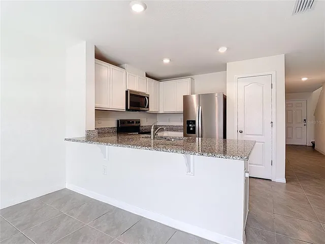a kitchen with kitchen island a sink stainless steel appliances and cabinets