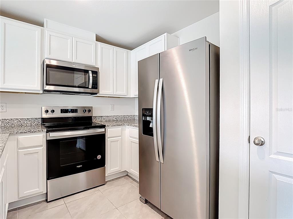 6632 Druid Way St. Cloud, FL 34773 - Photo 8 of 38 a kitchen with stainless steel appliances a refrigerator stove and microwave