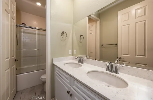 a bathroom with a granite countertop sink a toilet and shower