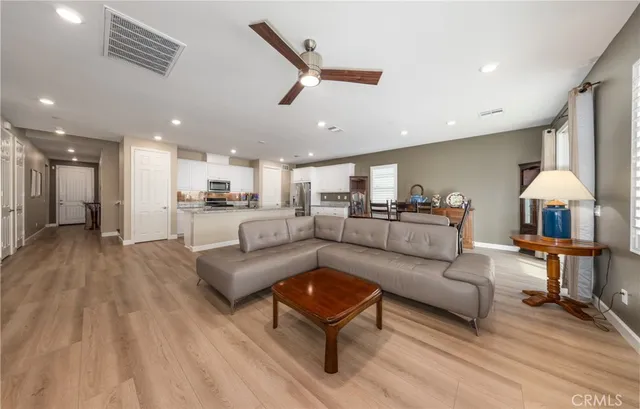 a living room with furniture and a wooden floor