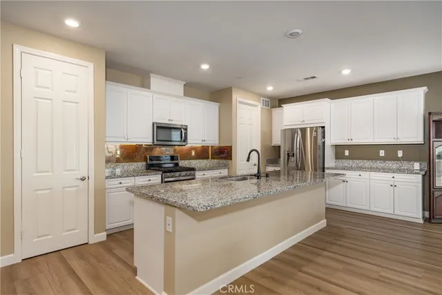 a kitchen with stainless steel appliances granite countertop a stove a sink and a refrigerator