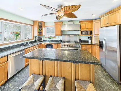 a kitchen with stainless steel appliances granite countertop a sink and a microwave