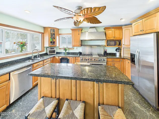 a kitchen with stainless steel appliances granite countertop a sink and a microwave