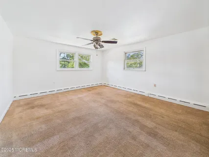 an empty room with windows and fan