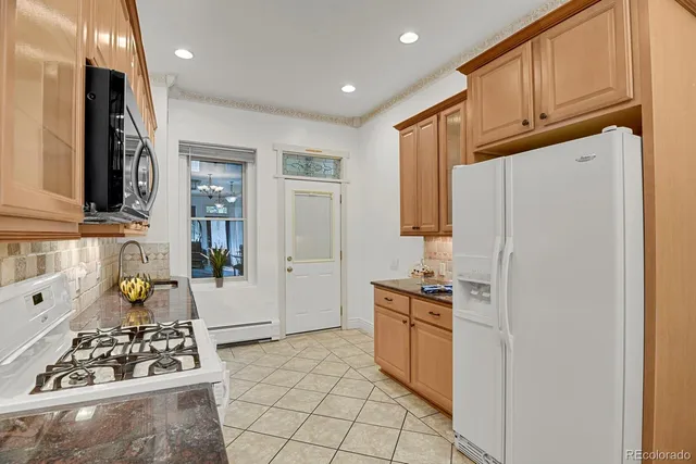 a kitchen with stainless steel appliances granite countertop a refrigerator and a stove top oven