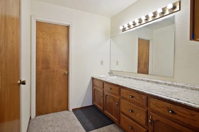 a bathroom with a granite countertop sink and a mirror