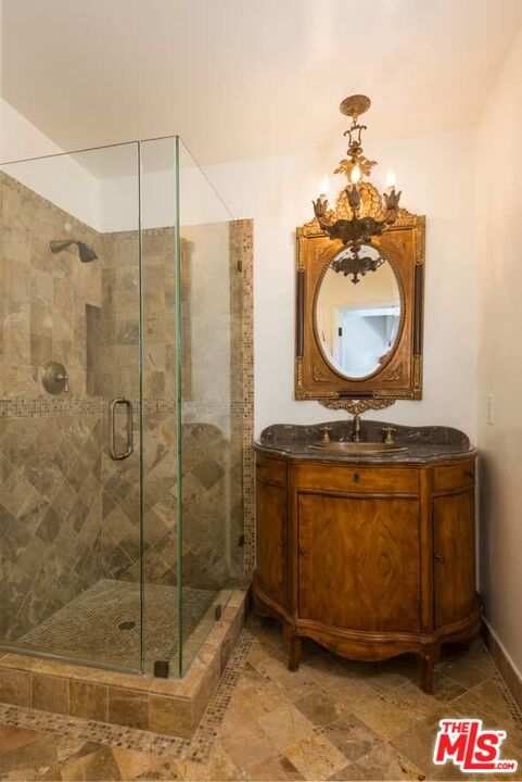1957 Mandeville Canyon Road Los Angeles, CA 90049 - Photo 26 of 54 a bathroom with a sink a mirror and shower