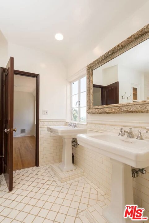 1957 Mandeville Canyon Road Los Angeles, CA 90049 - Photo 30 of 54 a bathroom with a sink vanity and mirror