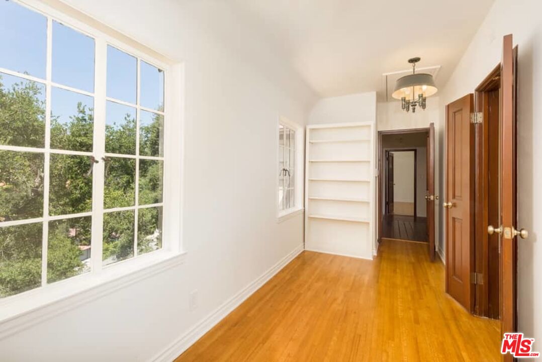 1957 Mandeville Canyon Road Los Angeles, CA 90049 - Photo 33 of 54 a view of a bedroom with wooden floor and a window