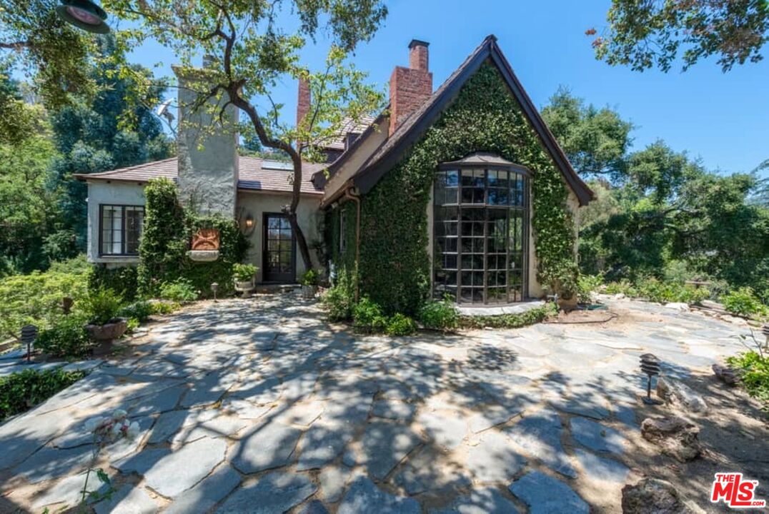 1957 Mandeville Canyon Road Los Angeles, CA 90049 - Photo 4 of 54 a view of a house with a tree